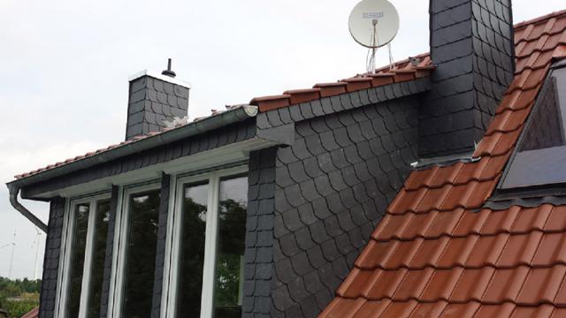 Traufpartie eines Hauses mit grauem Schiefer und roten Biberschwanzziegeln